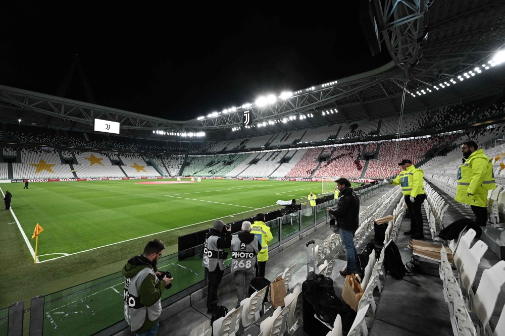 Photographers take pictures of the empty Juventus stadium before the Italian Serie A football match Juventus vs Inter Milan which will be played behind closed doors, in Turin on March 8, 2020. AFP / Vincenzo Pinto 