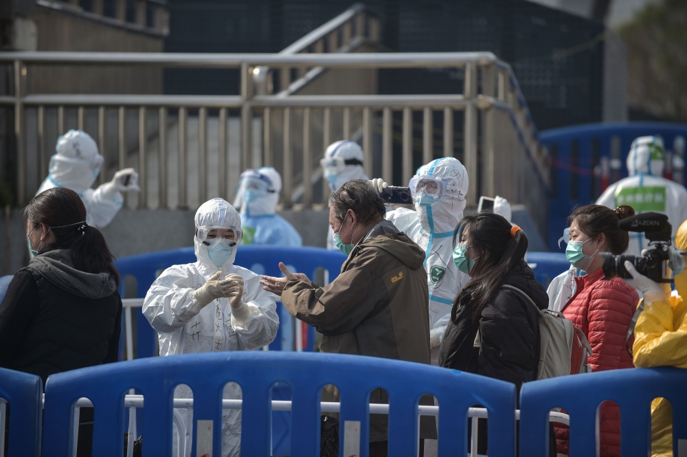 People who have recovered from the COVID-19 coronavirus infection leave Wuchan makeshift hospital in Wuhan in China's central Hubei province on March 10, 2020. / AFP / STR