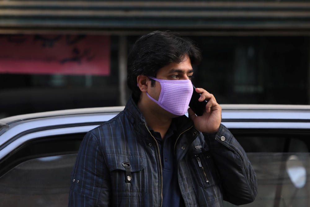 A man wears a face mask as a preventive measure following the coronavirus outbreak, as he talks on mobile phone in Peshawar, Pakistan March 10, 2020. Reuters/Fayaz Aziz
 