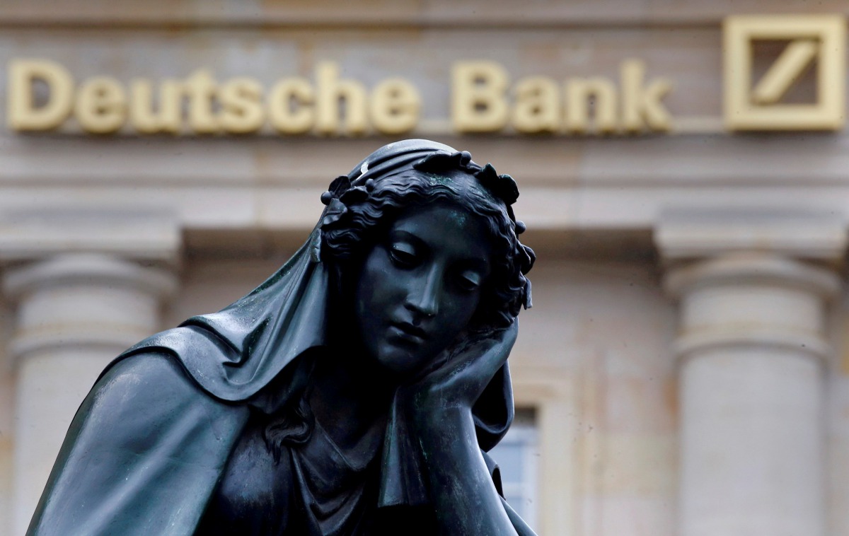 A statue is seen next to the logo of Germanys Deutsche Bank in Frankfurt, January 26, 2016. Reuters /  Kai Pfaffenbach