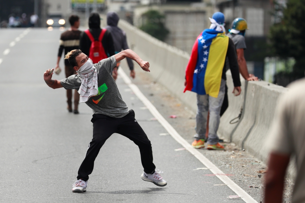 A demonstrator throws a rock during a protest in Caracas, Venezuela March 10, 2020. Reuters/Carlos Jasso 
 