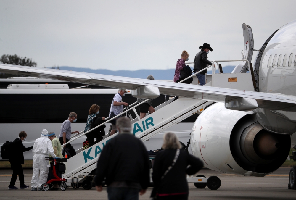 Passengers from the Princess Cruises Grand Princess cruise ship board a charter plane at Oakland International Airport on March 10, 2020 in Oakland, California.  Justin Sullivan / AFP