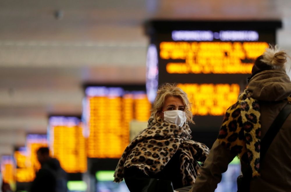 A woman wears a protective face mask at Roma Termini railway station, after the Italian government imposed a virtual lockdown on the north of the country, in Rome, Italy, March 8, 2020. REUTERS/Yara Nardi