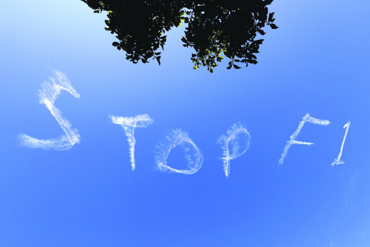 The words 'Stop F1' are seen over the Sydney sky yesterday.  Three Formula One team staff members have been isolated at the Australian Grand Prix while tests are conducted for the new coronavirus, officials said, casting a shadow over the opening race of 