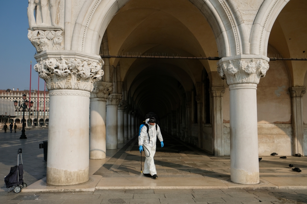 A worker sanitises the Doges Palace on St. Mark's square as a measure to fight against the coronavirus contagion in Venice, Italy, March 12, 2020. REUTERS/Manuel Silvestri