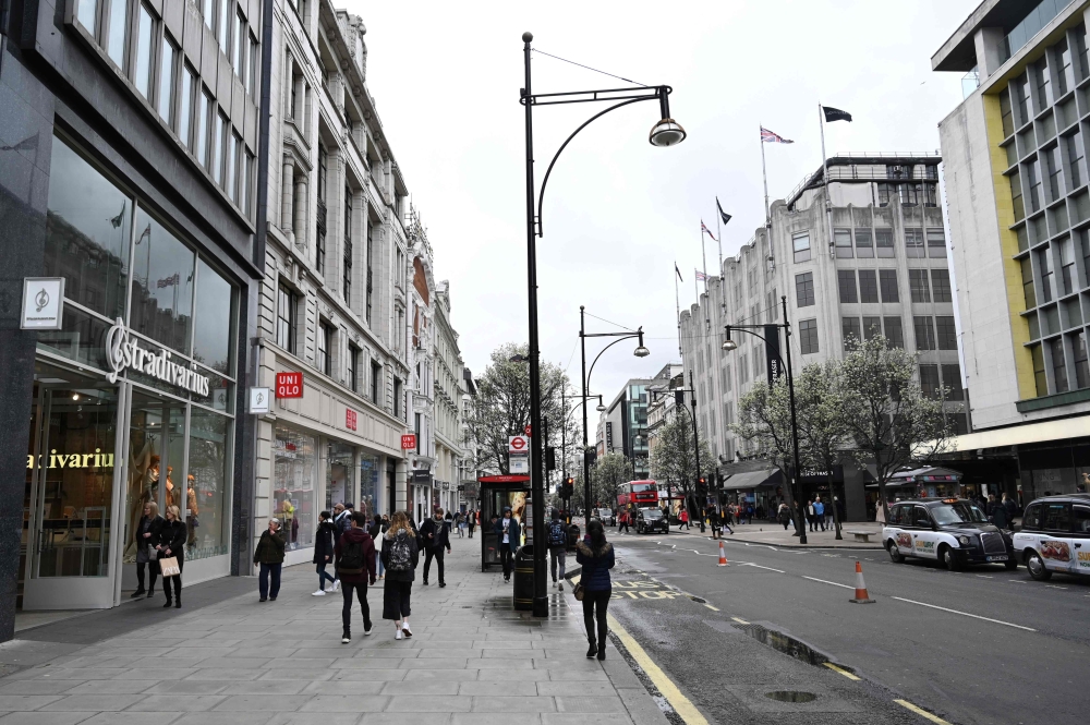 Shoppers walk on a quiet Oxford Street, central London on March 14, 2020. AFP / Glyn KIRK