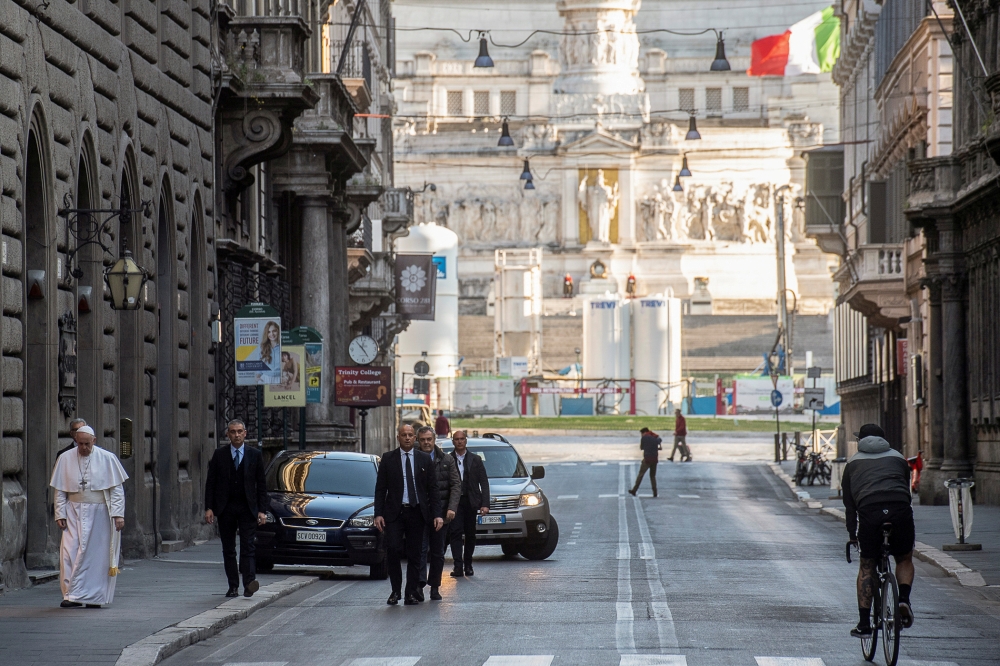 Pope Francis walks in a deserted Rome to pray at two shrines for the end of the coronavirus pandemic, in Rome, Italy March 15, 2020. Vatican Media / Reuters