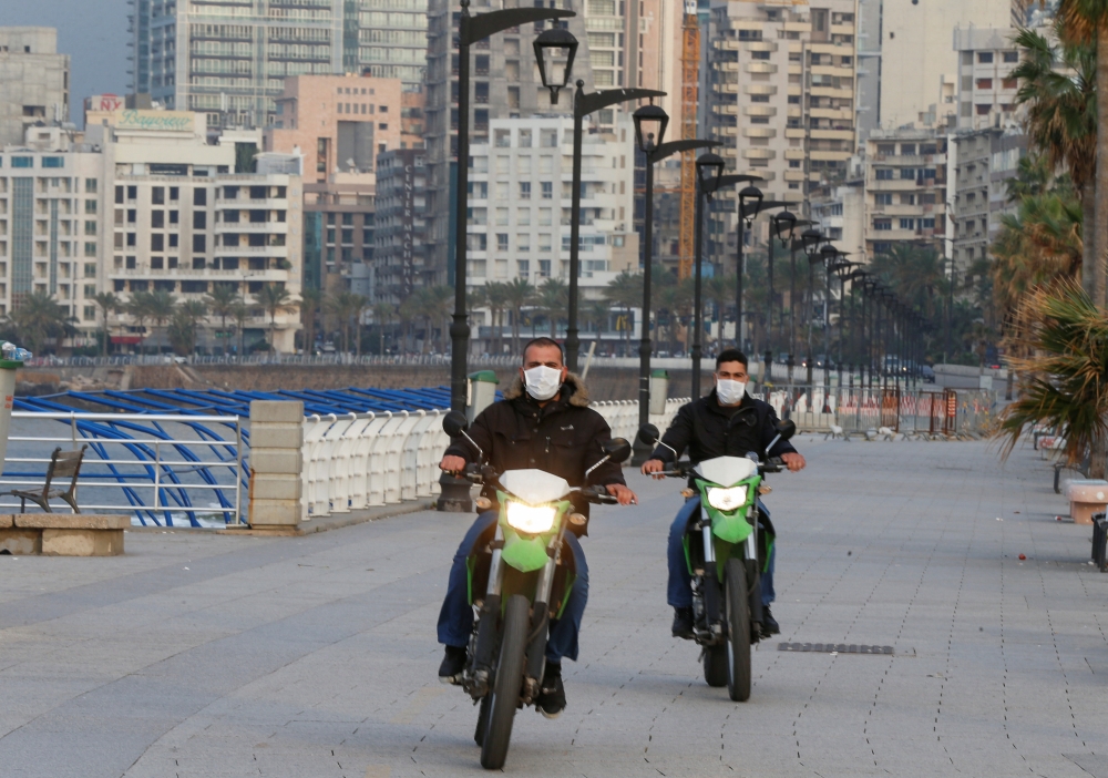 Police members wear face masks as they ride on motorbikes at Beirut's seaside Corniche as Lebanon declared a medical state of emergency on Sunday as part of the preventive measures against the spread of the coronavirus, in Beirut, Lebanon March 15, 2020. 