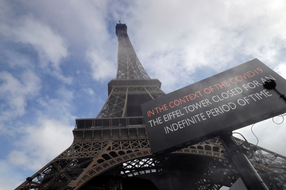  TOPSHOT - A picture taken on March 14, 2020 near the eiffel tower in Paris shows a board informing of the monument's closure as a precaution against the coronavirus. / AFP / Thomas SAMSON