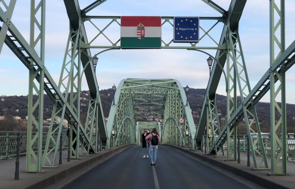 People take pictures on the Hungary-Slovakia border bridge in Esztergom Hungary, March 14, 2020. Slovakia closed the border for non Slovak pasport holders as a preventive measure against the coronavirus (COVID-19). REUTERS/Krisztina Than