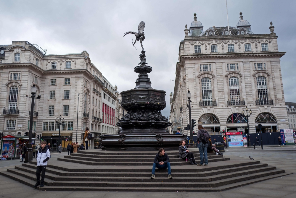 Only a few people are pictured in Piccadilly Circus on Sunday afternoon in central London on March 15, 2020. AFP / Tolga Akmen 