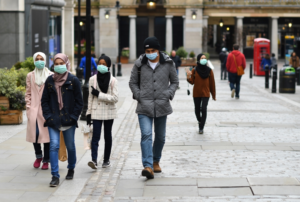 People wearing protective face masks in Covent Garden, London as the number of coronavirus cases grow around the world. London, Britain, March 17, 2020. REUTERS/Dylan Martinez