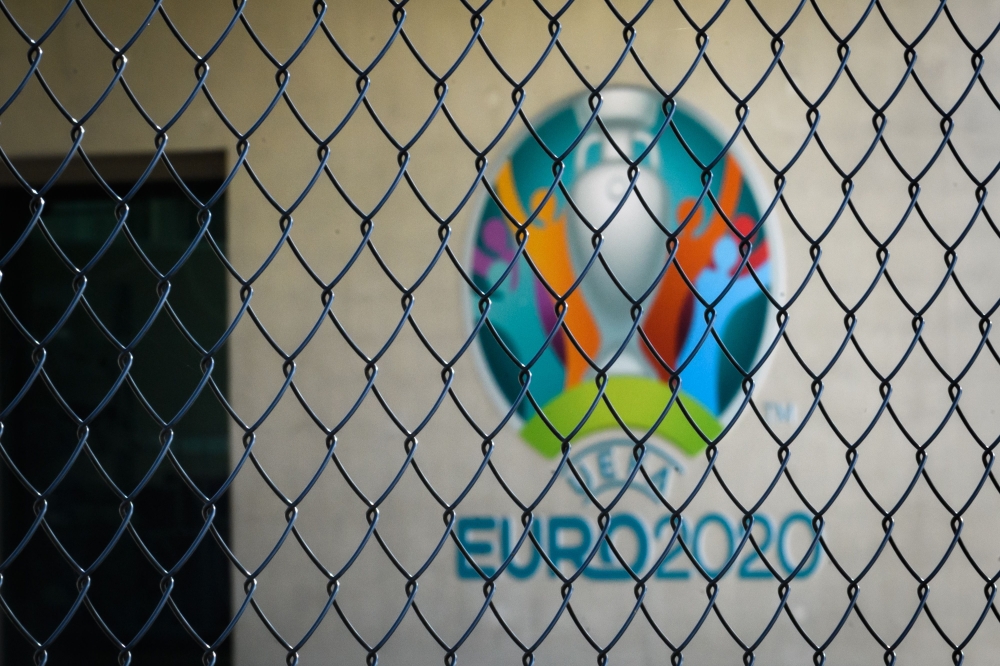 The Euro 2020 logo behind a fence at the headquarters of UEFA, the European football's governing body, amid spread of novel coronavirus (COVID-19).  AFP / FABRICE COFFRINI