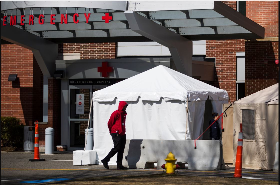 A tent is erected for screening people with flu-like symptoms, in connection with the coronavirus pandemic outside the South Shore Hospital's emergency department in Weymouth, Mass. Photo by Adam Glanzman for The Washington Post