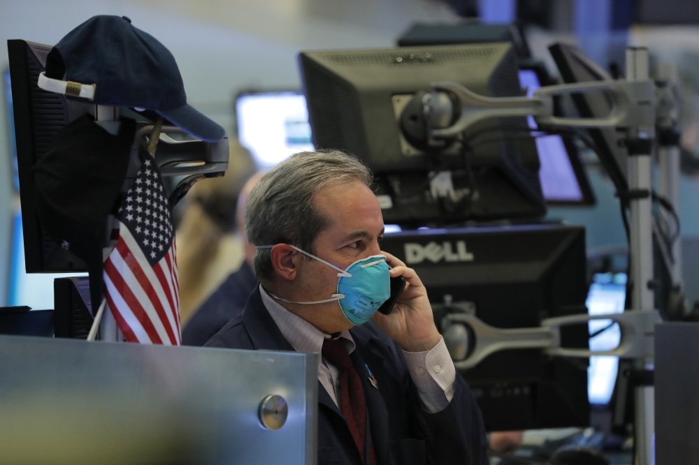 A trader wears a face mask on the floor of the New York Stock Exchange (NYSE) following traders testing positive for Coronavirus disease (COVID-19), in New York, March 19, 2020. Reuters/Lucas Jackson
 
 
  