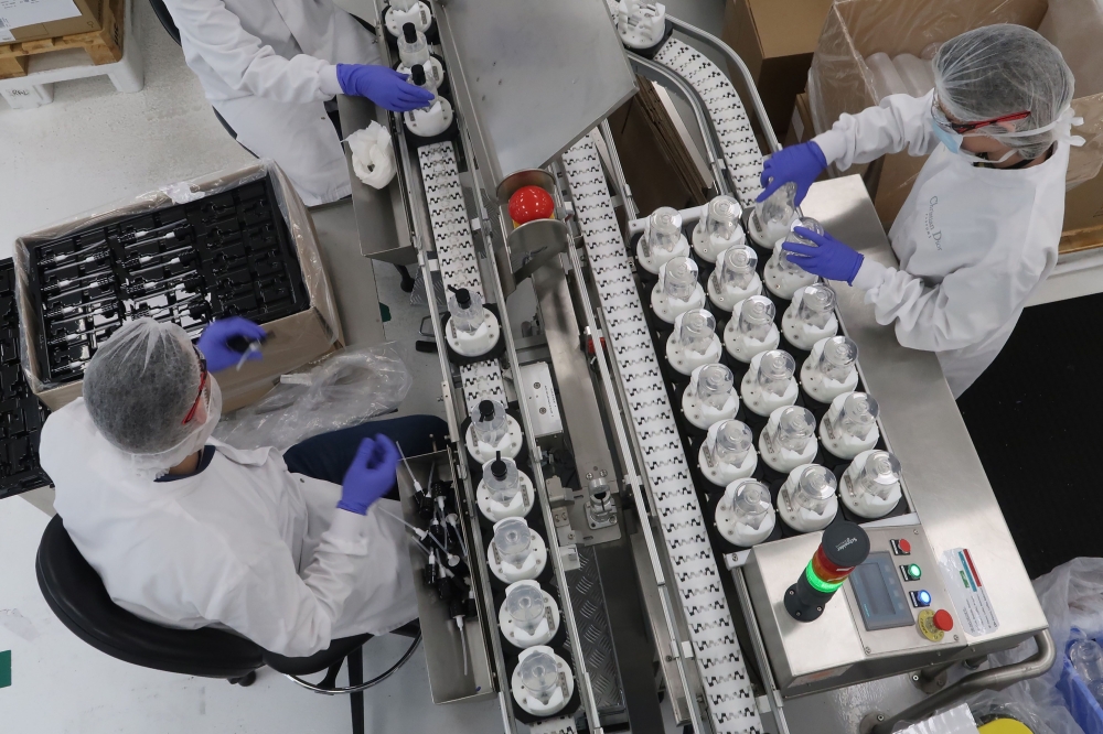 This handout picture taken on March 16, 2020 and released by French luxury group LVMH on March 17, 2020 shows workers at the Christian Dior cosmetics and perfume factory in Jean-de-Braye making hand sanitizers to be given for free for Paris' hospitals (AP