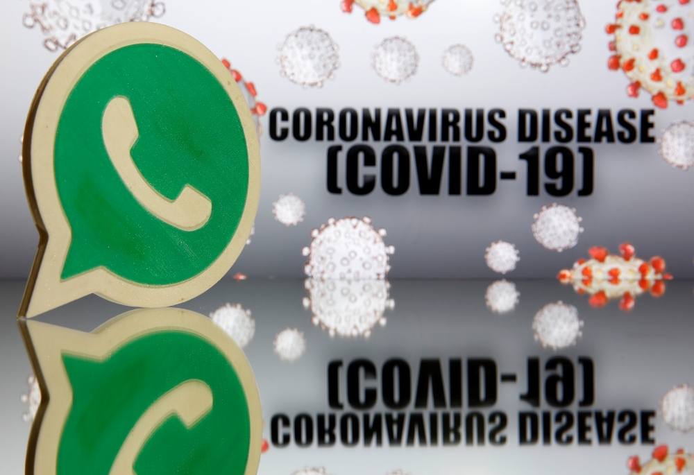 A 3D-printed Whatsapp logo is seen in front of displayed coronavirus disease (COVID-19) sign in this illustration taken March 19, 2020. REUTERS/Dado Ruvic/Illustration