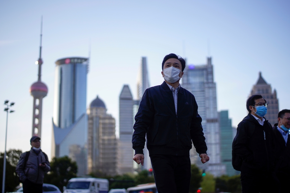 FFILE PHOTO: People wear protective face masks, following an outbreak of the novel coronavirus disease (COVID-19), at Lujiazui financial district in Shanghai, China March 19, 2020. REUTERS/Aly Song - RC22NF9MD3D3/File Photo/File Photo
