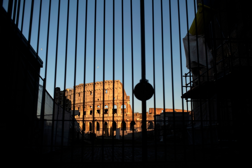 This picture taken on March 23, 2020 in Rome, shows a view of the Colosseum monument along a deserted Via dei Fori Imperiali during the country's lockdown aimed at stopping the spread of the COVID-19 (new coronavirus) pandemic. , / AFP / Filippo MONTEFORT
