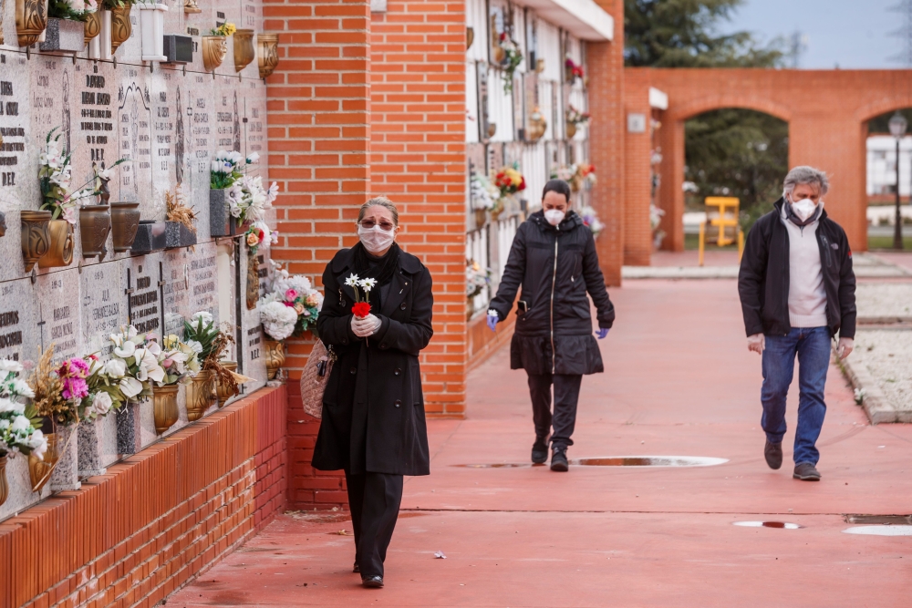 People wearing face masks arrive at the South Municipal cemetery in Madrid, on March 23, 2020, to attend the burial of a man who died of the new coronavirus./ AFP / BALDESCA SAMPER
