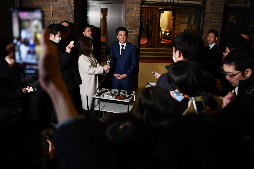 Japan's Prime Minister Shinzo Abe speaks to the press in front of the prime minister's residence in Tokyo on March 24, 2020.   AFP / CHARLY TRIBALLEAU
