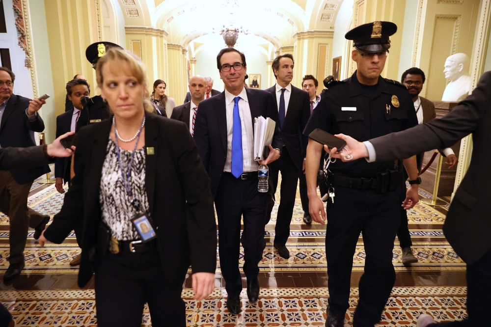 Treasury Secretary Steven Mnuchin (C) leaves the offices of Minority Leader Charles Schumer (D-NY) as negotiations continue into the night on a $2 trillion economic stimulus in response to the coronavirus pandemic at the U.S. Capitol March 24, 2020 in Was