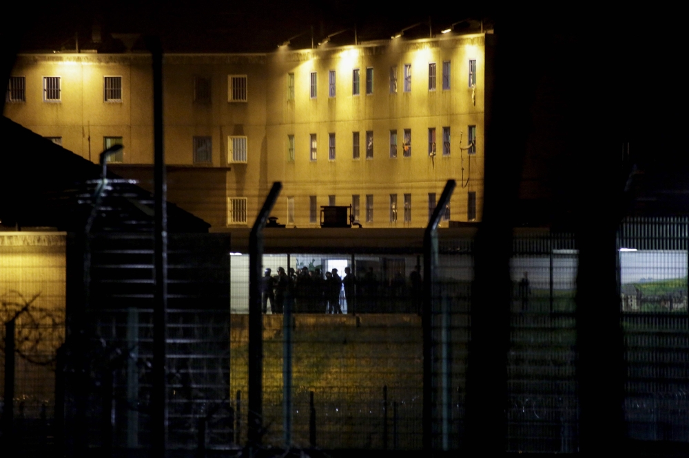 Members of ERIES, the Regional Response and Security Team, stand ready to intervene at the detention centre of Uzerche, central France, as inmates gathered on the roof of the prison, on March 22, 2020, after visiting hours for families and relatives of th