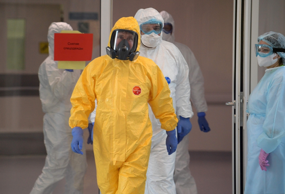 Russian President Vladimir Putin wearing protective gear visits a hospital where patients infected with the COVID-19 novel coronavirus are being treated in the settlement of Kommunarka in Moscow on March 24, 2020. / AFP / SPUTNIK / Alexey DRUZHININ