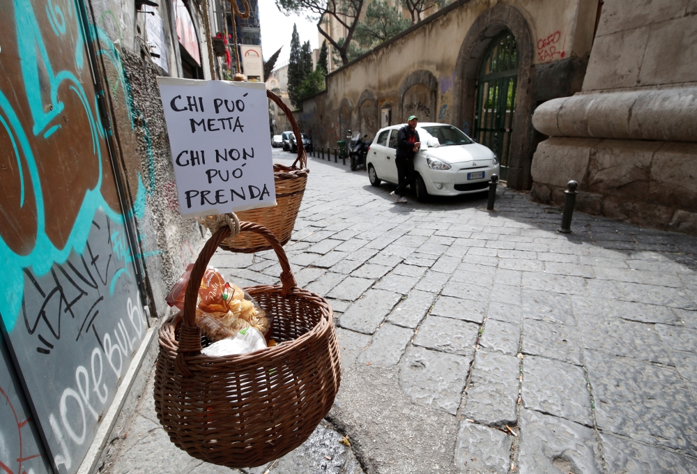 A basket hung up so people can donate or take for free food is seen, as Italy struggles to contain the  COVID-19 in Naples, Italy March 30, 2020. The sign reads: 