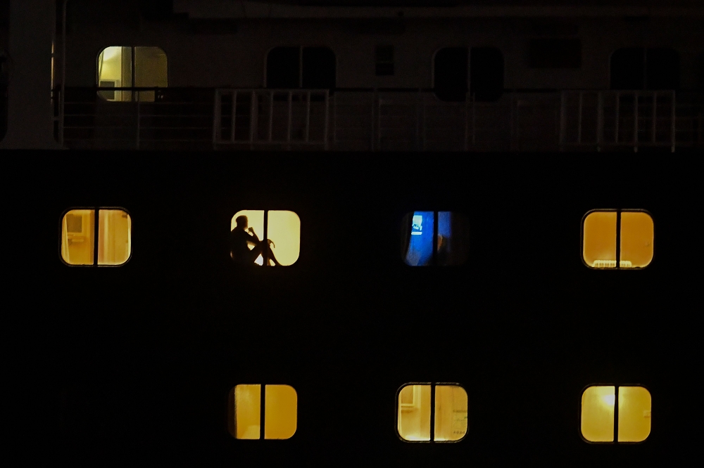 Passangers of Holland America's cruise ship Zaandam are seen as the ship navigates through the Panama Canal in Panama City, on March 29, 2020. AFP / Luis Acosta
 