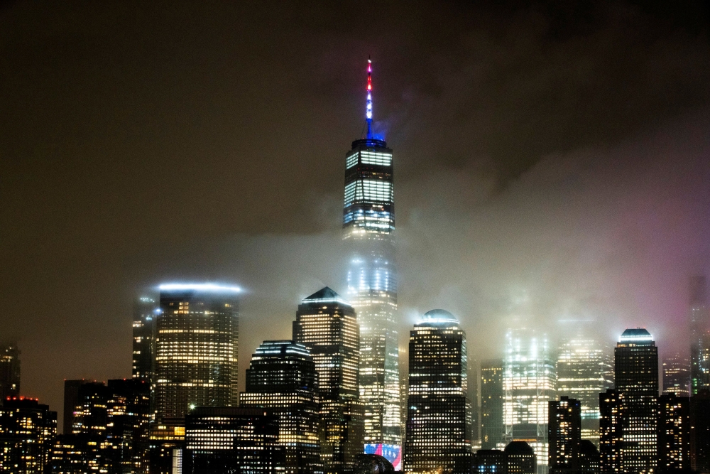 The One World Trade Center is illuminated in red, white and blue in recognition of the ongoing nationwide effort to combat coronavirus during the outbreak of the coronavirus disease (COVID-19) in New York City, as it is seen from Exchange Place, New Jerse