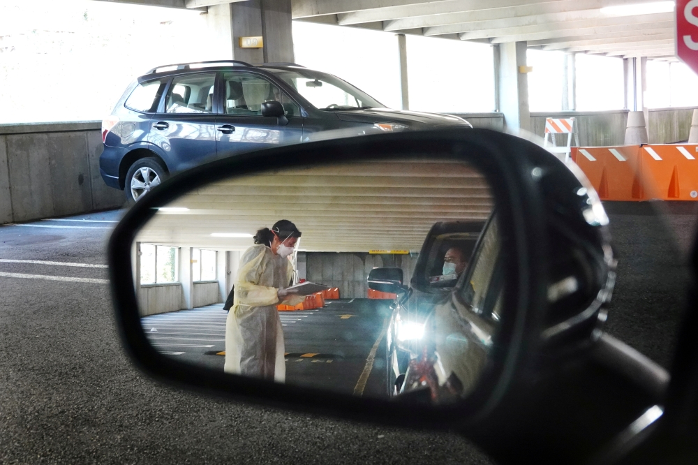 FILE PHOTO: Medical personnel wear protective gear while working at a drive-through testing site for coronavirus disease (COVID-19) in Greenwich, Connecticut, U.S., March 27, 2020. Reuters/Lucas Jackson/File Photo