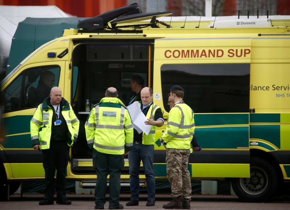 Paramedics and military personnel are seen outside the Excel Centre, London while it is being prepared to become the NHS Nightingale Hospital, as the spread of the coronavirus disease (COVID-19) continues, London, Britain, April 1, 2020. REUTERS/Henry Nic