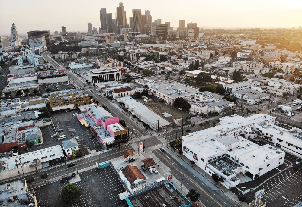 LOS ANGELES, CALIFORNIA - APRIL 04: An aerial view of mostly empty streets and parking lots with the downtown skyline in the background amid the coronavirus pandemic on April 4, 2020 in Los Angeles, California. Mario Tama/AFP

