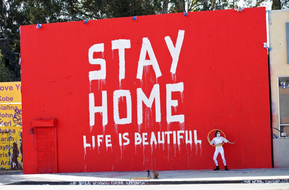 Dance instructor Morgan Jenkins makes a video in front of a mural during the global outbreak of the coronavirus disease (COVID-19), in Los Angeles, California, U.S., April 3, 2020. REUTERS/Mario Anzuoni