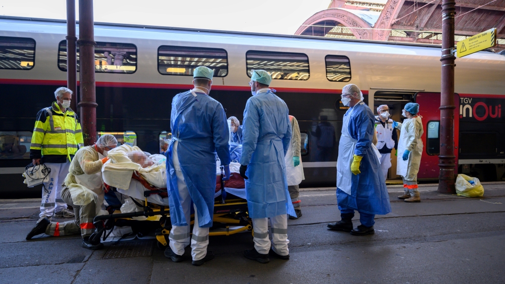 Medical staff carry a patient infected with the COVID-19 onboard a medicalized TGV high speed train at the railway station in Strasbourg, France, April 3, 2020. Patrick Hertzog/Pool via Reuters
