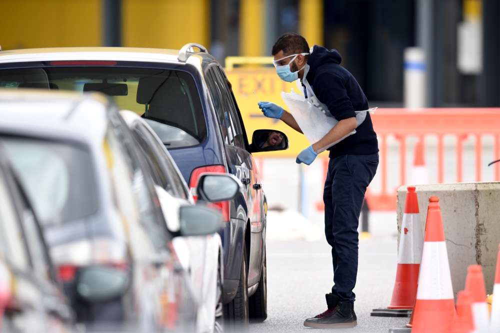 NHS workers check people at a coronavirus (COVID-19) drive-through testing station set up at the Wembley IKEA store for NHS staff on April 1, 2020 in London, United Kingdom. Kate Green - Anadolu 
