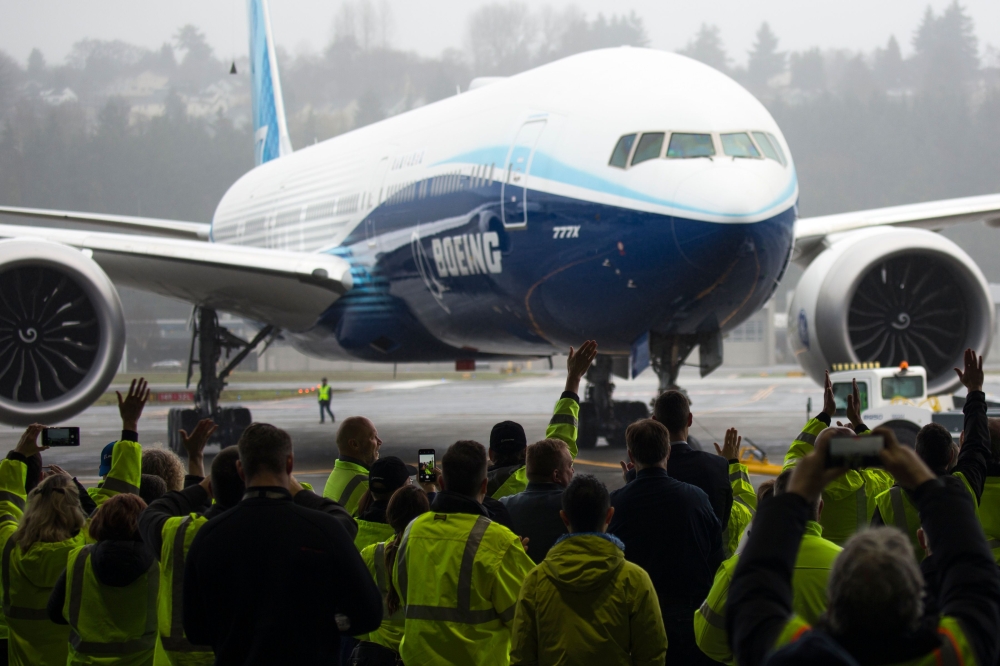 In this file photo taken on January 25, 2020, Boeing employees and guests welcome a Boeing 777X airplane returning from its inaugural flight at Boeing Field in Seattle, Washington. / AFP / Jason Redmond
