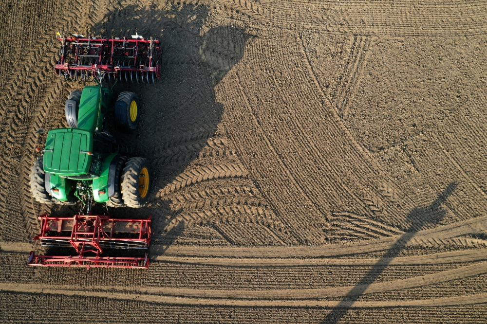 FILE PHOTO: A French farmer drives his tractor to prepare the land before sugar beets sowing in Anneux, France, March 27, 2020. Picture taken with a drone. REUTERS/Pascal Rossignol/File Photo