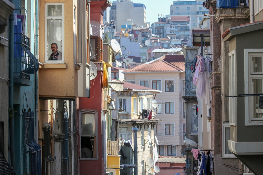 A man watches bakers, who brought bread, from their home after a two-day curfew imposed to stem the spread of the coranavirus (COVID-19) in Istanbul, Turkey on April 12, 2020.  Kaan Bozdo?an - Anadolu