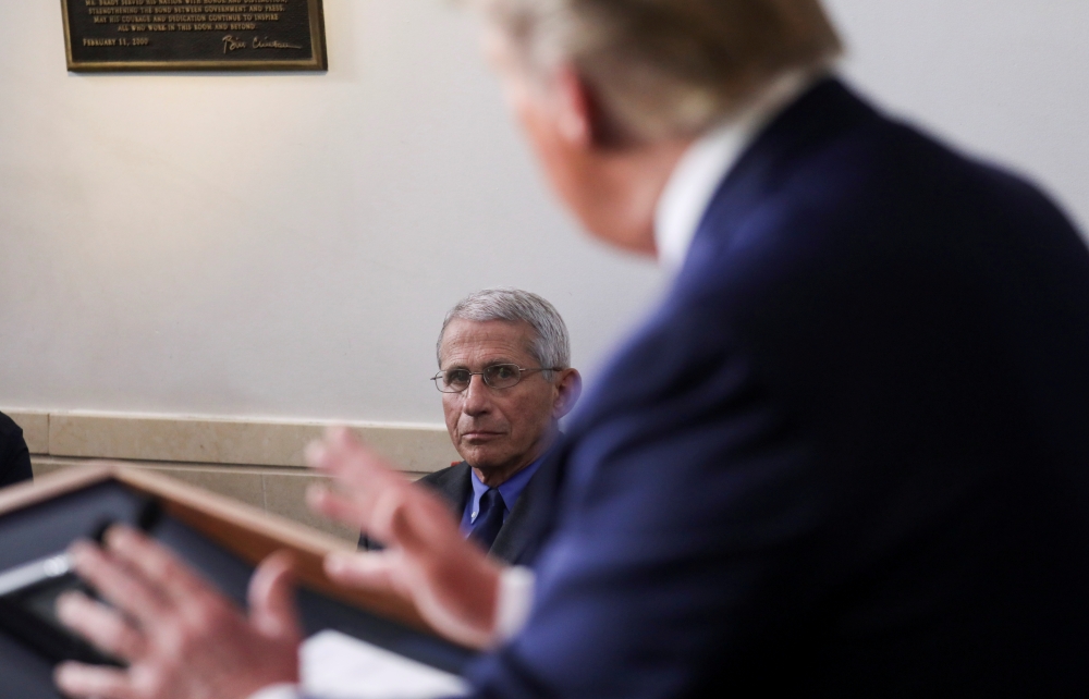 National Institute of Allergy and Infectious Diseases director Dr. Anthony Fauci listens to U.S. President Donald Trump speak during the daily coronavirus task force briefing at the White House in Washington, US, April 13, 2020. REUTERS/Leah Millis