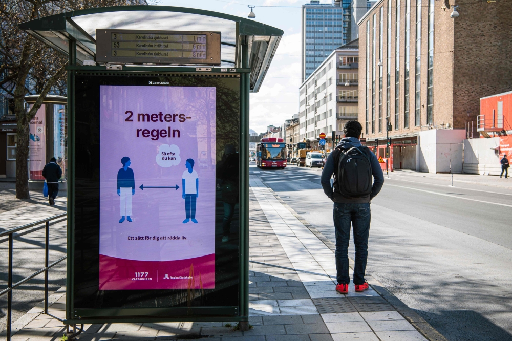An advertisement of the healthcare services of Sweden instructs people to follow the 2 meters rule to reduce the risk of getting sick, in Stockholm on April 14, 2020. / AFP / Jonathan NACKSTRAND