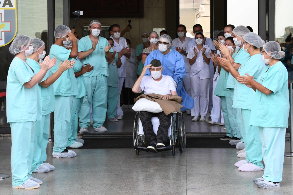 TOPSHOT - Brazilian 99-year-old former WWII combatant Ermando Armelino Piveta, gestures as leaves the Armed Forces Hospital in Brasilia, after being treated for the novel coronavirus COVID-19 and discharged, on April 14, 2020. / AFP / EVARISTO SA