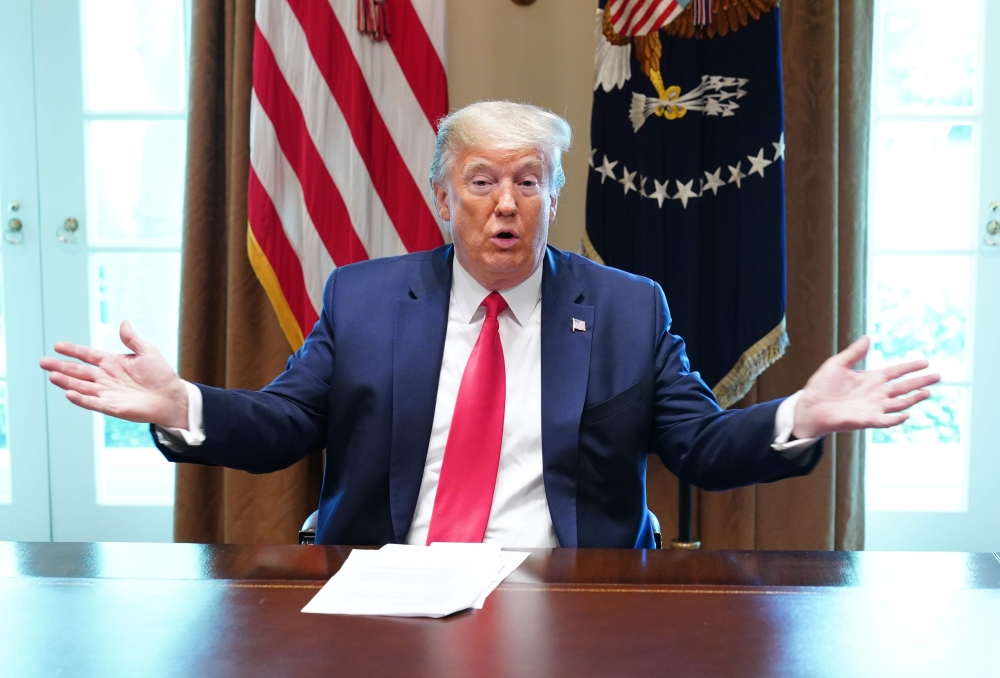 US President Donald Trump speaks during a meeting with patients who have recovered from the novel coronavirus, COVID-19, in the Cabinet Room of the White House in Washington, DC on April 14, 2020.  / AFP / MANDEL NGAN