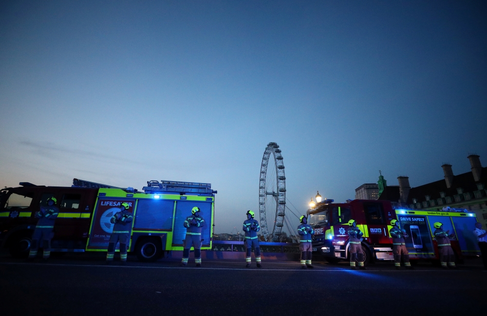 Firefighters applaud on Westminster bridge during the Clap for our Carers campaign in support of the NHS as the spread of the coronavirus disease (COVID-19) continues, London, Britain, April 9, 2020. REUTERS/Hannah McKay
