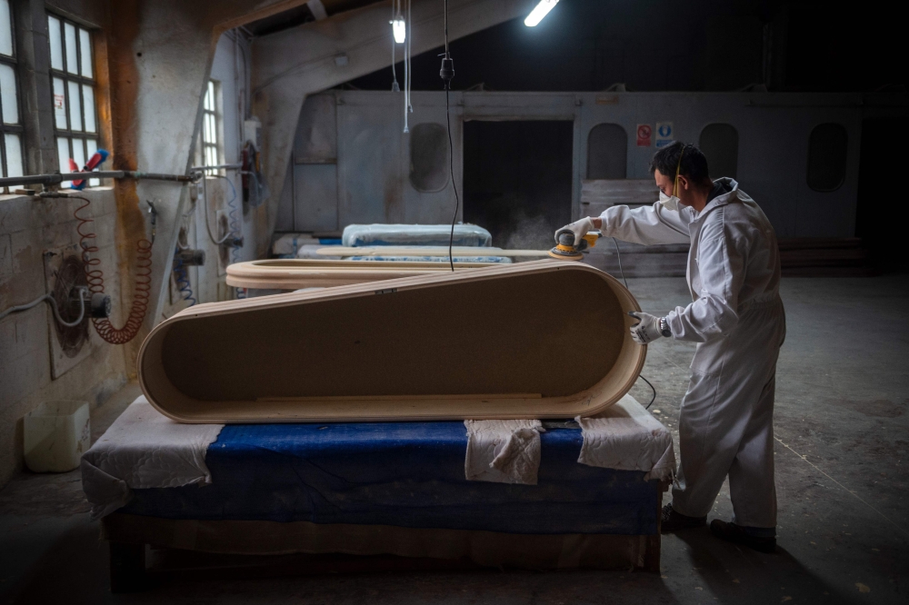 An employee makes a coffin at the Yago Gonzalez coffin-making factory in Pinor, northwestern Spain, on April 14, 2020.  AFP / MIGUEL RIOPA