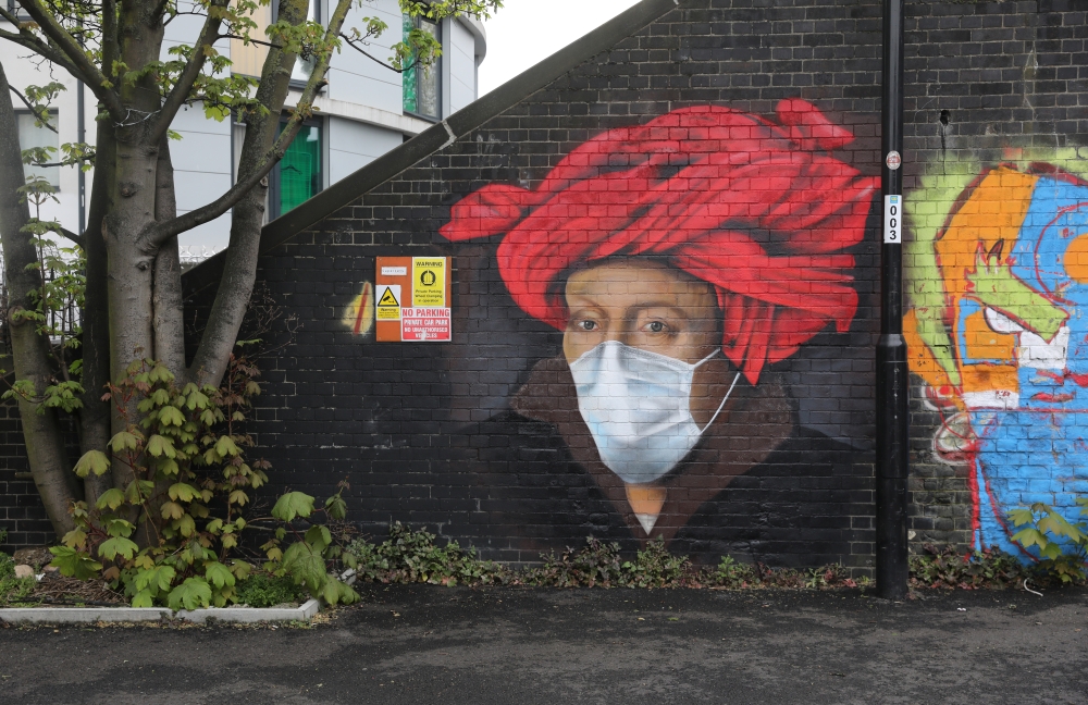 Street art depicting a painting by Jan van Eyck with a face mask is seen in Ladywell, as the spread of the coronavirus disease (COVID-19) continues, London, Britain, April 18, 2020. REUTERS/Simon Dawson