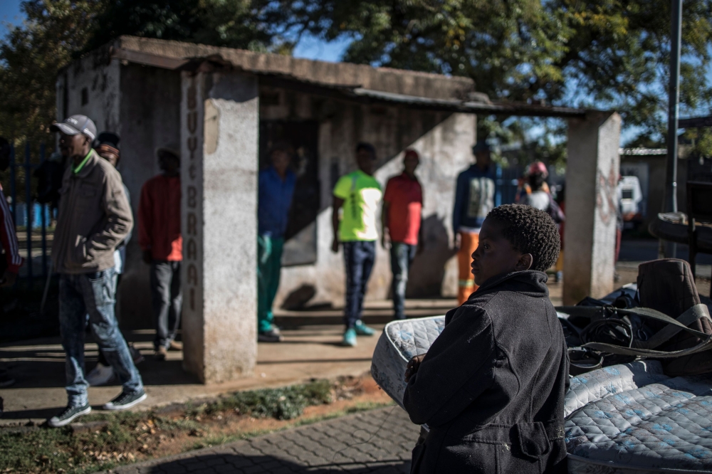 Informal traders and waste-pickers queue at the parking lot of the Orlando East Communal Hall in Soweto, Johannesburg, on April 17, 2020 during a food distribution. AFP / MARCO LONGARI