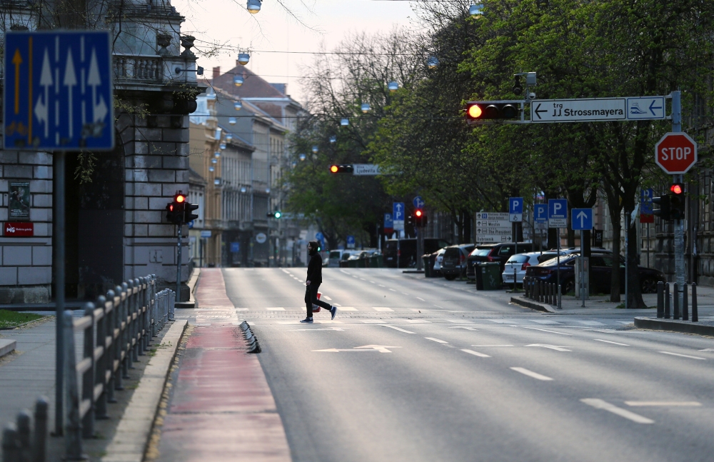 FILE PHOTO: A man crossing a street as Croatia is stepping up measures to fight the coronavirus disease (COVID-19) outbreak, in Zagreb, Croatia March 21, 2020. REUTERS/Antonio Bronic