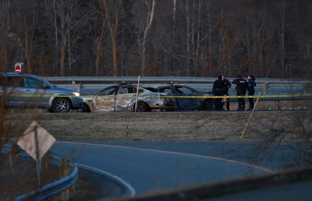 RCMP officers go over a car collision scene involving the fake RCMP car driven by Gabriel Wortman in Shubenacadie, Nova Scotia, Canada April 19, 2020. REUTERS/John Morris TPX IMAGES OF THE DAY